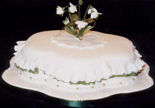 A petal shape rich fruit cake with sugar crafted snowdrops and double frills.